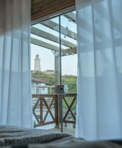 a bedroom with a window with a view of a lighthouse at Loft Casa no Farol in Laguna