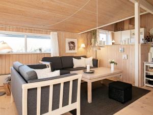een woonkamer met een bank en een tafel bij 6 person holiday home in Hj rring in Sønderlev