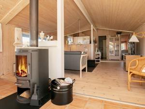 - un salon avec une cheminée dans une maison dans l'établissement 6 person holiday home in Hj rring, à Sønderlev