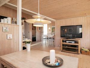 uma sala de estar com televisão e uma vela sobre uma mesa em 6 person holiday home in Hj rring em Sønderlev