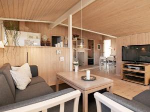 6 person holiday home in Hj rring في Sønderlev: غرفة معيشة مع أريكة وطاولة وتلفزيون