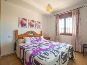 sypialnia z łóżkiem z kolorową narzutą w obiekcie Belvilla by OYO Apartamento en Palomares w mieście Palomares
