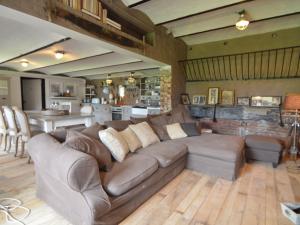 a living room with a brown couch and a kitchen at Holiday home in West Flanders with garden and bubble bath in Pittem