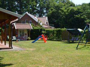 a yard with playground equipment in front of a house at Holiday home in Lindern with garden in Werlte