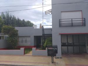 a white building with a gate and a balcony at Apartamento El Calvario 4 in Tandil