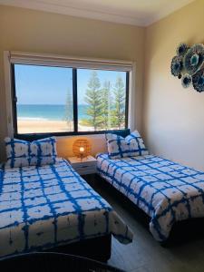 a bedroom with two beds and a large window at The Fisherman's Shack in The Entrance