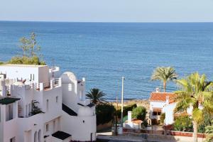 un bâtiment blanc avec des palmiers et l'océan dans l'établissement Golden Paradise 75 by homeprive, à Jávea