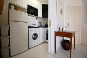 Il comprend une cuisine équipée d'un réfrigérateur blanc et d'un lave-linge. dans l'établissement Golden Paradise 75 by homeprive, à Jávea