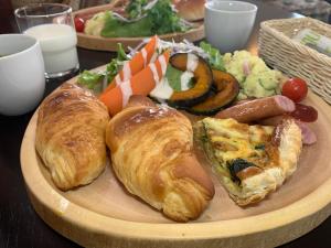 a plate of food with croissants and other foods at Pension Lavender in Furano +3 photos