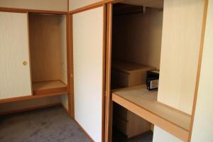 a walk in closet with wooden cabinets and a appliance at The Ridge Hakuba Hotel & Apartments in Hakuba
