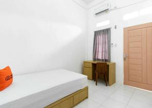 Schlafzimmer mit einem Bett und einer Holztür in der Unterkunft KoolKost near Wisata Purwahamba Indah Tegal in Tegal