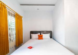 Schlafzimmer mit einem Bett mit orangefarbenem Kissen in der Unterkunft KoolKost near Wisata Purwahamba Indah Tegal in Tegal
