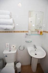 Baño blanco con aseo y lavamanos en The Rosscourt-Adults Only en Bournemouth