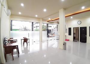 a living room with a table and a clock on the wall at RedDoorz Syariah near Transmart Jambi 2 in Paalmerah