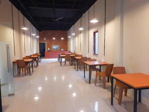 a row of tables and chairs in a restaurant at RedDoorz Syariah near Transmart Jambi 2 in Paalmerah
