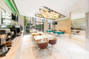 um restaurante com mesas, cadeiras e janelas em iclub AMTD Sheung Wan Hotel em Hong Kong