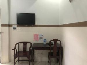 um quarto com duas cadeiras e uma mesa e uma televisão em Mai Vuong Thuy Hotel em Thu Dau Mot
