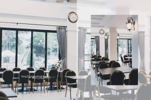 a room with tables and chairs and a clock on the wall at Lailaresidence in Yala