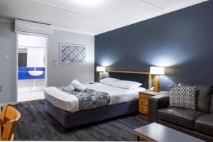 une chambre d'hôtel avec un lit et un canapé dans l'établissement Country Motel Ipswich, à Ipswich