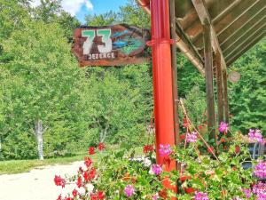 a sign on a red pole with flowers at House Angie in Jezerce