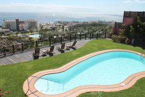 ein Swimmingpool an der Seite eines Gebäudes in der Unterkunft Villa Dara in Playa del Ingles