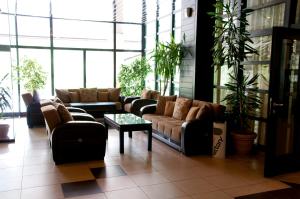 a living room with couches and tables and plants at Everest Hotel in Etropole