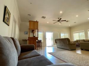 sala de estar con sofá y ventilador de techo en Lambert Estate Retreat, en Angaston