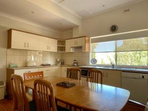 a kitchen with a wooden table and a table and chairs at Lambert Estate Retreat in Angaston