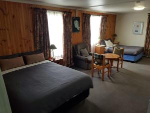 um quarto de hotel com uma cama, um sofá e uma mesa em Clunes Motel em Clunes