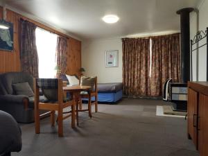a living room with a couch and a table and a bed at Clunes Motel in Clunes