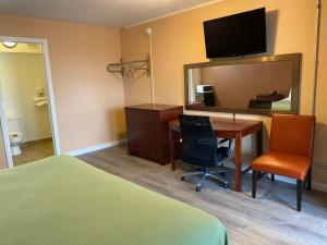 een slaapkamer met een bureau, een spiegel en een bed bij Travel Inn in Broadview