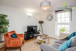 a living room with a couch and a tv at Windsor, 2 Bedroom Apartment By Sentinel Living Short Lets & Serviced Accommodation Windsor Ascot Maidenhead With Free WiFi in Windsor