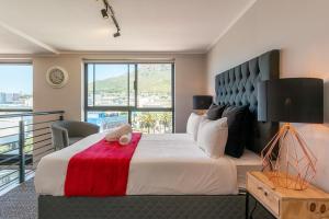 sypialnia z dużym łóżkiem i czerwonym kocem w obiekcie Penthouse 2 Bedroom - Biscuit Mill- Apartment w Kapsztadzie