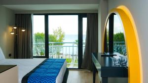 a hotel room with a bed and a large window at Sea City Devran Hotel & Spa in Antalya