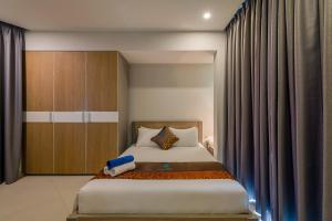 a bedroom with a bed and a wooden cabinet at Nipola Hotel - Chợ Đêm Dương Đông Phú Quốc in Phú Quốc