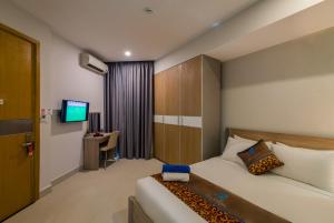 a hotel room with a bed and a television at Nipola Hotel - Chợ Đêm Dương Đông Phú Quốc in Phú Quốc