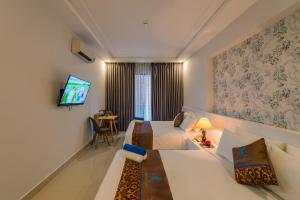 a hotel room with two beds and a television at Nipola Hotel - Chợ Đêm Dương Đông Phú Quốc in Phú Quốc