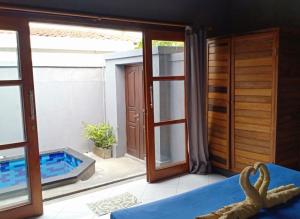 a room with a view of a swimming pool next to a door at Kawans Inn in Nusa Lembongan
