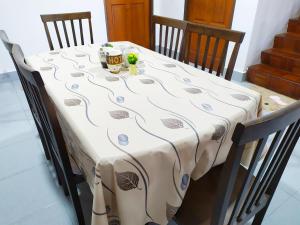 a table with a white table cloth with a cup on it at Victoria Homestay Sibu - Next to Shopping Complex, Party Event & Large Car Park Area with Autogate in Sibu