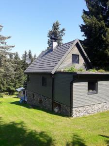 a house with a gambrel roof on a yard at Chata 100 Český Jiřetín in Český Jiřetín