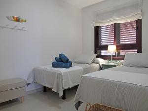 a bedroom with two beds with blue pillows on them at BARLOVENTO by RENTMEDANO Luxury beach front apartment with fantastic ocean views in El Médano
