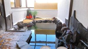 a room with a pond in the middle of a building at Sanso Tanaka in Yufuin