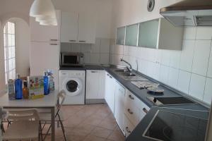 een keuken met een wastafel en een wasmachine bij Villa Dara in Playa del Inglés