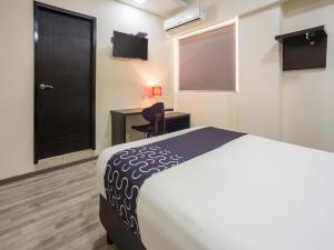 1 dormitorio con cama, escritorio y silla en Smart Hotel Monterrey, en Monterrey