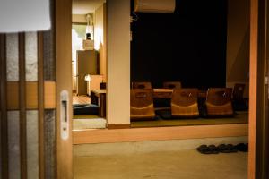 Biker's Inn Onomichi 自転車の宿おのみち في أونوميتشي: غرفة مع صف من الكراسي يجلسون في غرفة