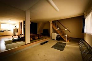 Biker's Inn Onomichi 自転車の宿おのみち في أونوميتشي: غرفة معيشة مع درج وغرفة معيشة