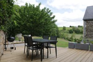 een zwarte tafel en stoelen op een houten terras bij La Belle Etoile in Avon-les-Roches