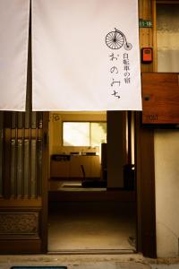 un panneau est sur la porte d'un bâtiment dans l'établissement Biker's Inn Onomichi 自転車の宿おのみち, à Onomichi