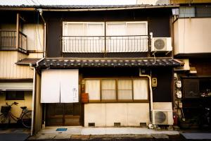 um edifício com duas portas de garagem e uma varanda em Biker's Inn Onomichi 自転車の宿おのみち em Onomichi