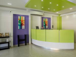 a lobby with colorful walls and a desk with a chair at Smart Hotel Monterrey in Monterrey